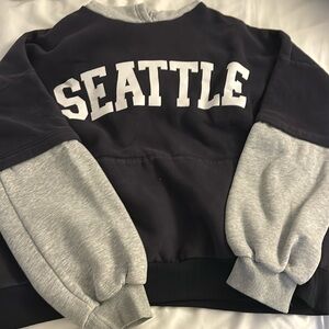 Navy hoodie with grey parts that says Seattle